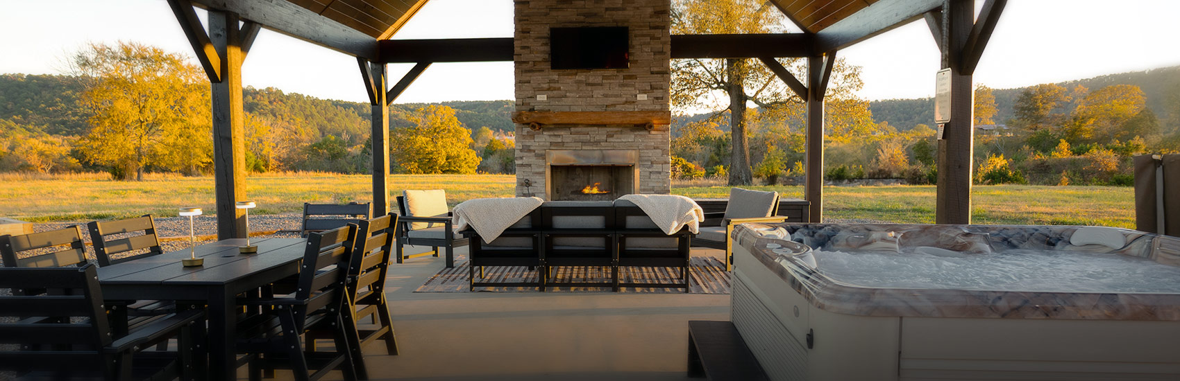outdoor pavilion with table, fireplace and hottub